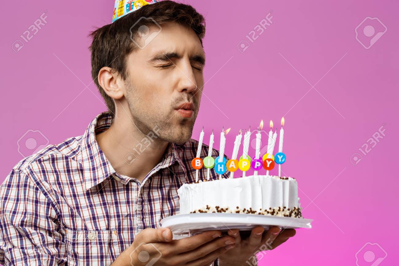 Man blowing out candles on birthday cake
