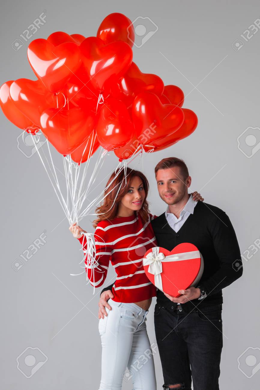 Imagen de una pareja celebrando con globos y regalos