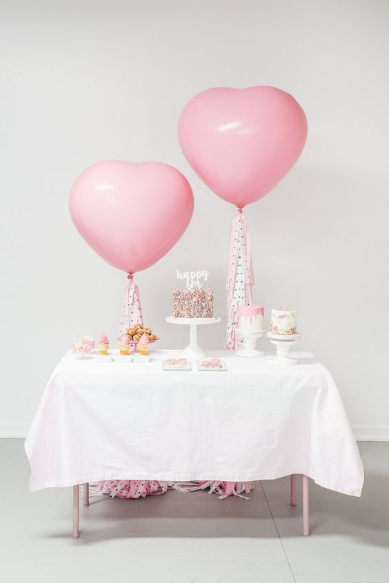 Imagen de una mesa decorada con globos y pastel