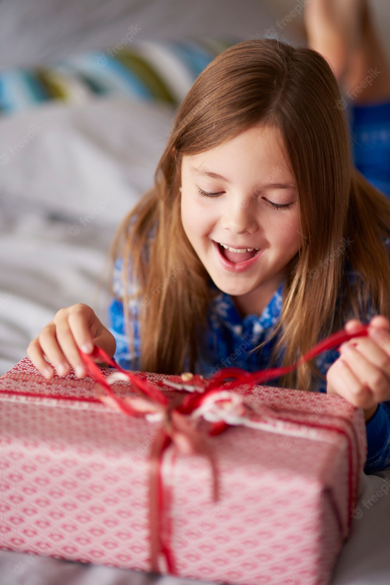 Un adolescente sonriente abriendo un regalo emocionante
