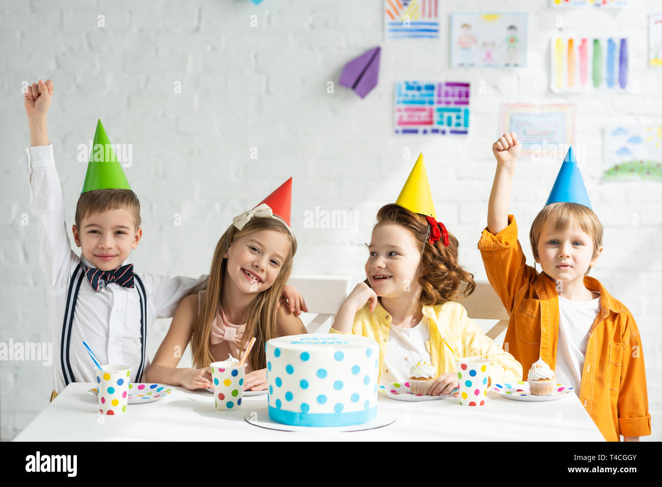 Happy children celebrating birthday with colorful party hats