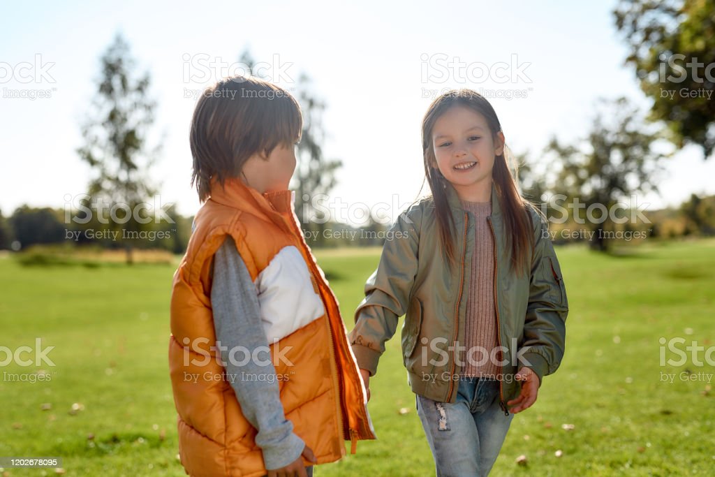 Happy siblings holding hands and smiling