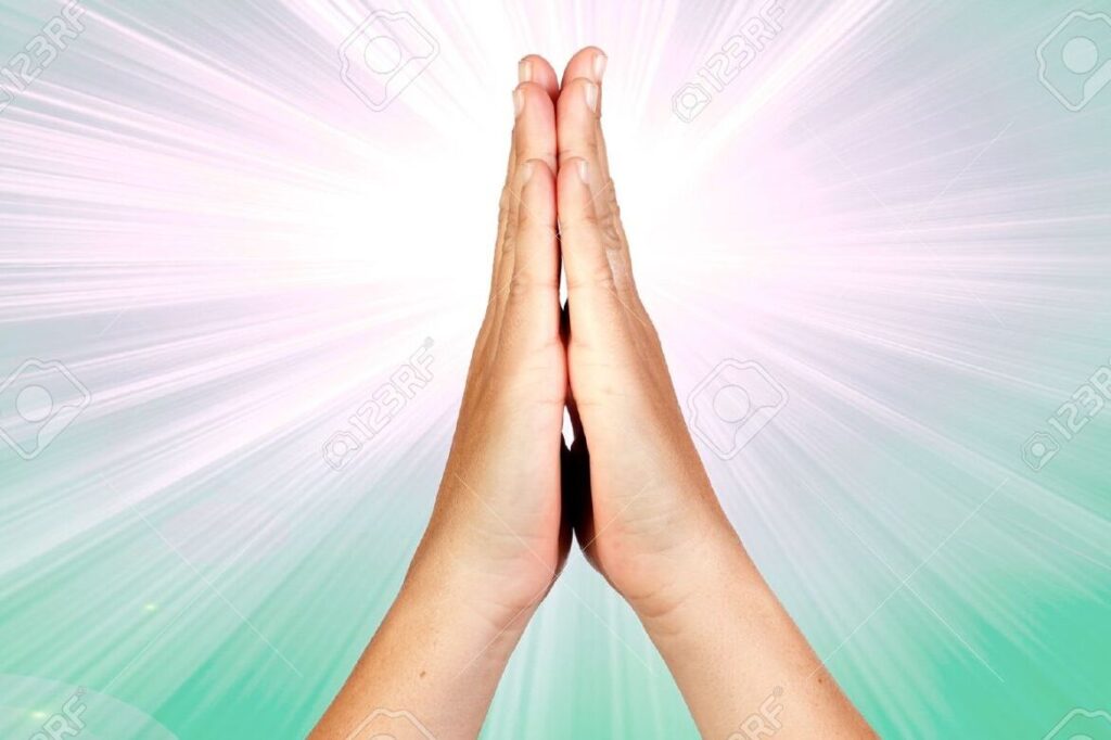 manos en oracion con rayos de luz