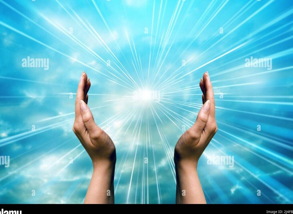 manos en posicion de oracion con luz divina