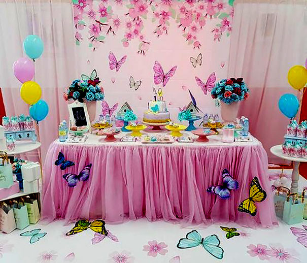 Imagen de una mesa decorada con mariposas y flores