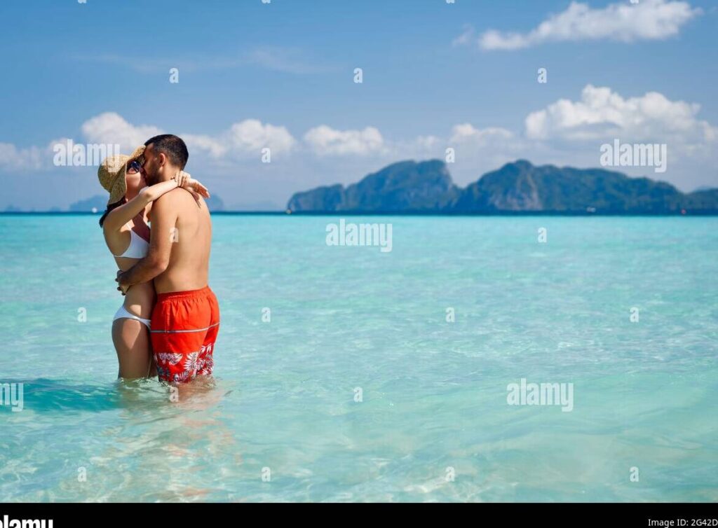 pareja besandose en una playa paradisiaca