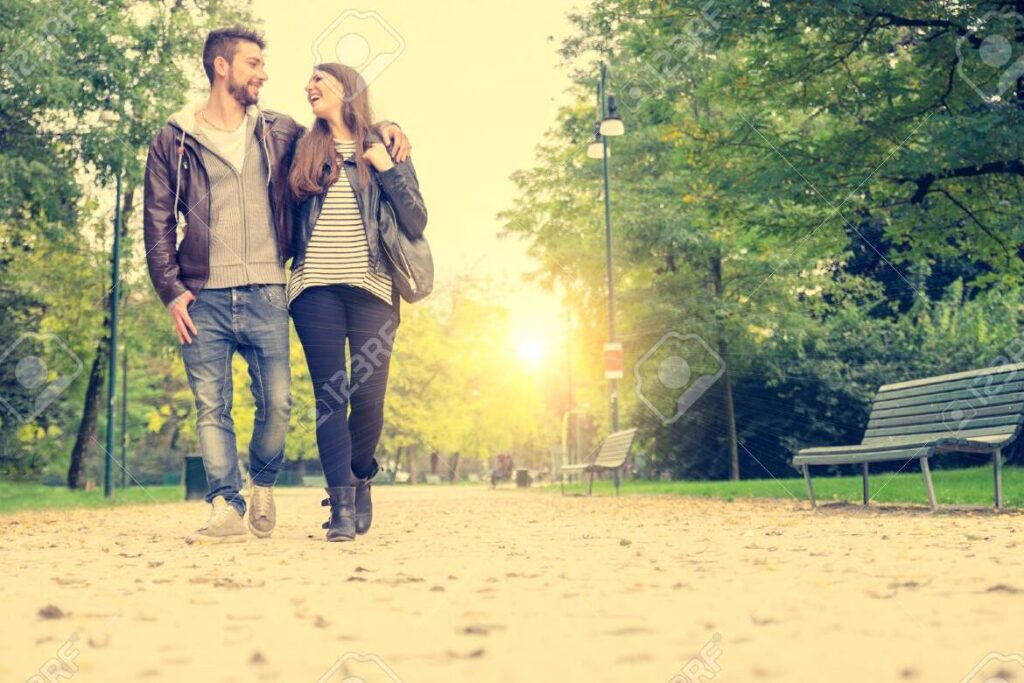 pareja caminando de la mano en un parque