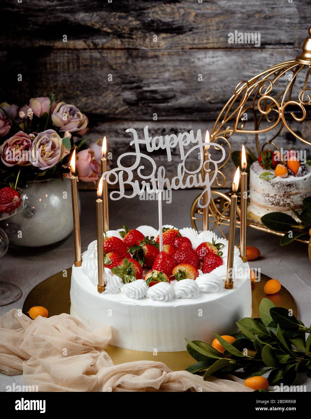 Imagen de un pastel de cumpleaños con velas doradas