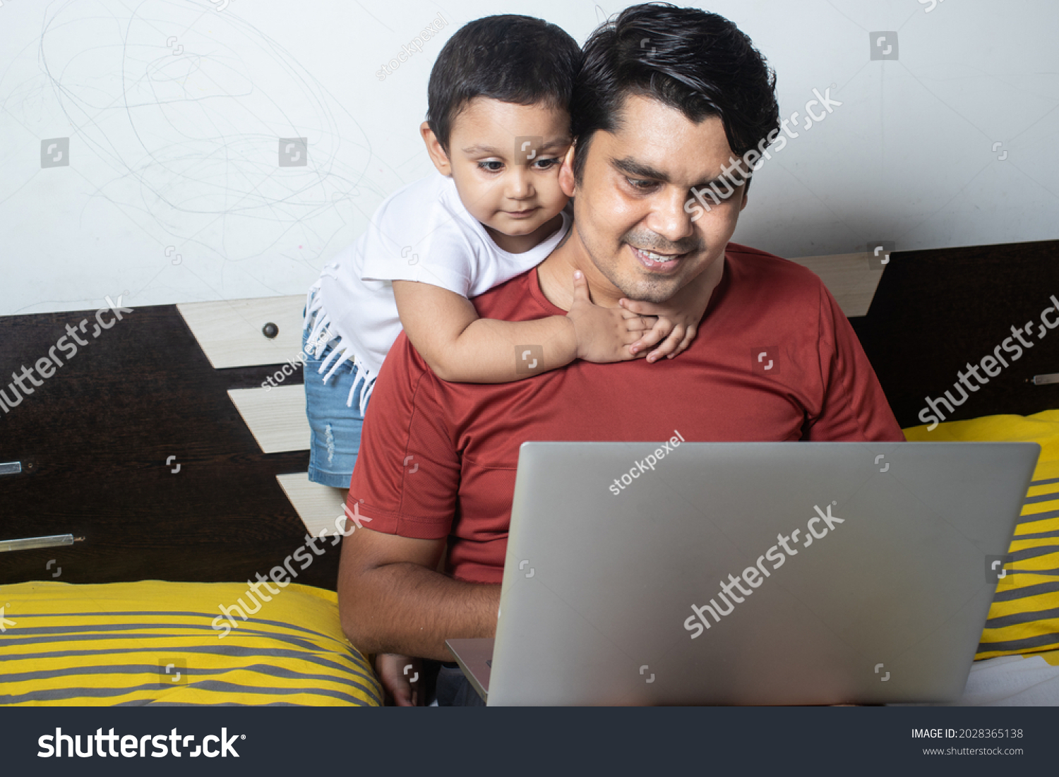 Father and child hugging through a computer screen
